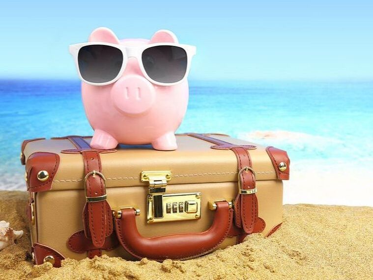 Money box pig on suitcase on oahu beach