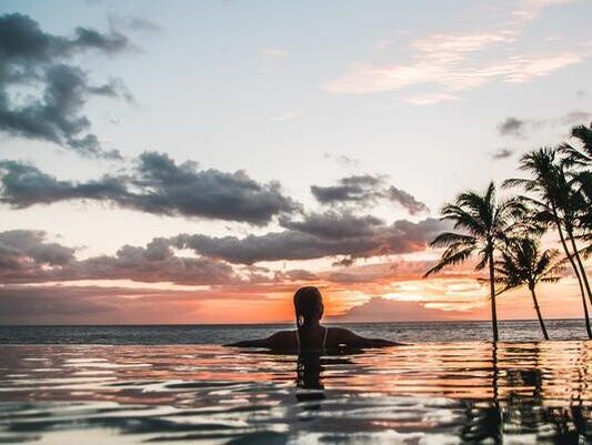 Woman in the pool overlooking the ocean